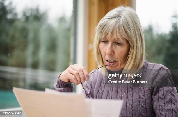 mujer mayor con problemas económicos - pensión documento bancario fotografías e imágenes de stock