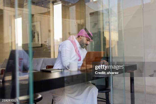 arab man in traditional attire working at a coffee shop - saudi arabia people stock pictures, royalty-free photos & images