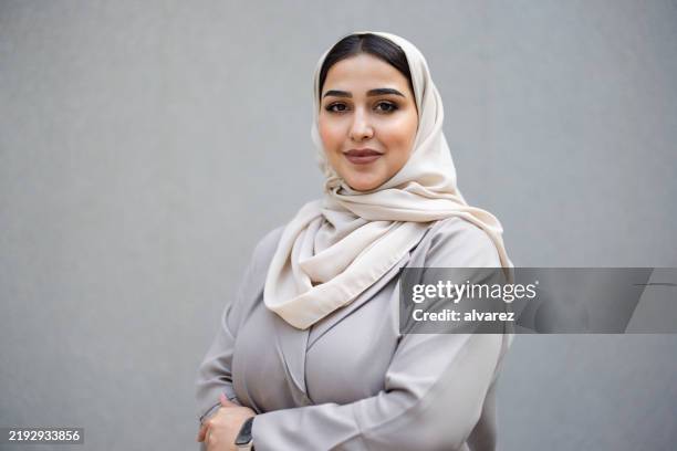 portrait de femme professionnelle confiante en abaya et hijab debout contre mur gris - voile religieux photos et images de collection