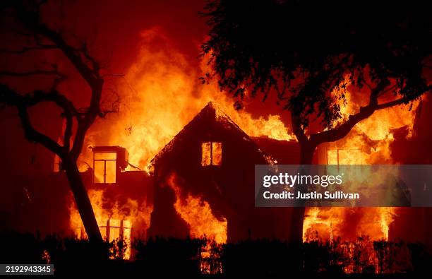 Fire engulfs a home as the Eaton Fire moves through the area on January 08, 2025 in Altadena, California. Fueled by intense Santa Ana Winds, the...