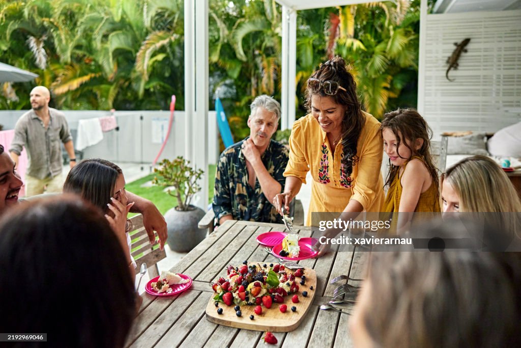 Family and friends watching as Pavlova dessert is served