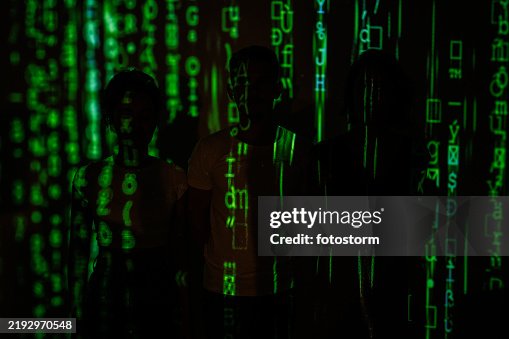 Three silhouettes with green digital code patterns projected onto their figures and background Three silhouettes with green digital code patterns projected onto their figures and background