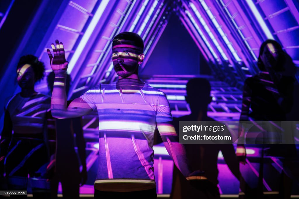 Person amidst neon projections in a futuristic vibrant environment with glowing patterns