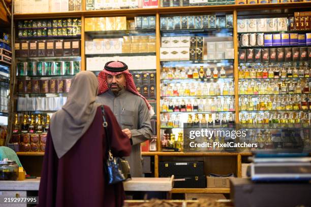 woman shopping in perfume store in souk in middle east - headdress stock pictures, royalty-free photos & images