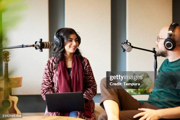 a woman and a man stream a live podcast interview in a sound studio. - radio broadcasting stock pictures, royalty-free photos & images