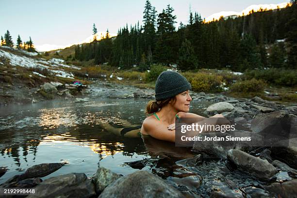 a woman soaking in conunderum hotsprings in colorado. - common aspen tree stock pictures, royalty-free photos & images