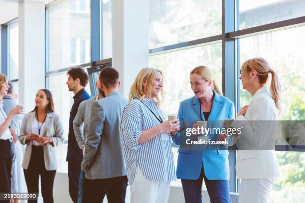 business people in convention center during coffee break - rompere il ghiaccio foto e immagini stock