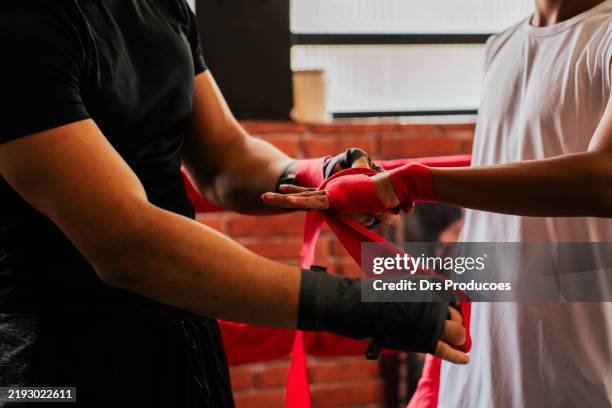 young man putting on boxing bandage - luva roupa desportiva de proteção imagens e fotografias de stock