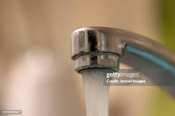 close up of water pouring out of a tap. - running water stock pictures, royalty-free photos & images