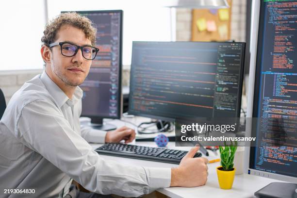 programmatore it sorridente che lavora su computer desktop. specialista maschile nella creazione di software innovativi. ingegnere che sviluppa app, programmi, videogiochi. scrittura di codice nel terminale - programmazione televisiva foto e immagini stock