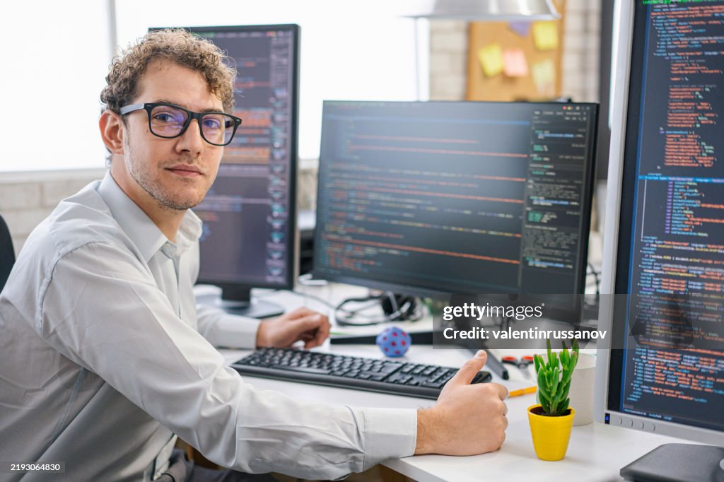 Smiling IT Programmer Working on Desktop Computer. Male Specialist Creating Innovative Software. Engineer Developing App, Program, Video Game. Writing Code in Terminal