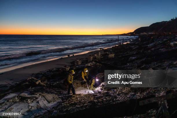 Fire fighters from Woodland Hills searches for hotspots in a burned home at Pacific Coast Highway on January 12, 2025 in the Pacific Palisades...