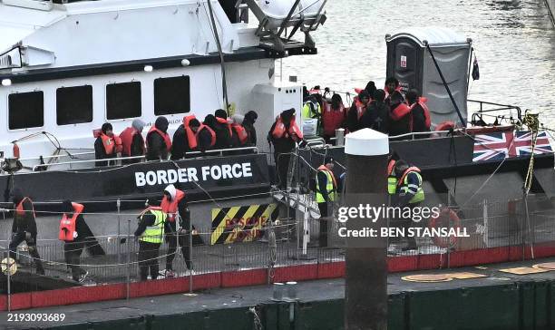 Migrants picked up at sea attempting to cross the English Channel from France, disembark from Border Force vessel 'Defender' after it arrived at the...