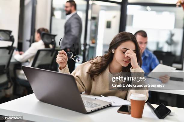 female dispatcher feeling overwhelmed after difficult call having headache from stress - irritatie stockfoto's en -beelden