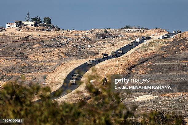 This picture taken from the Israeli side of the border with the Gaza Strip an Israeli army military convoy moving along a road inside the northern...
