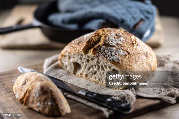 sliced fresh sourdough bread on a cutting board. - carbohidrato fotografías e imágenes de stock