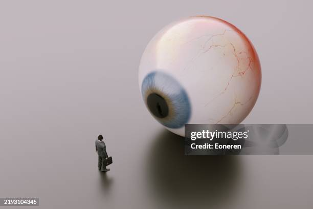 giant eyes looking at business man - cor do olho humano imagens e fotografias de stock