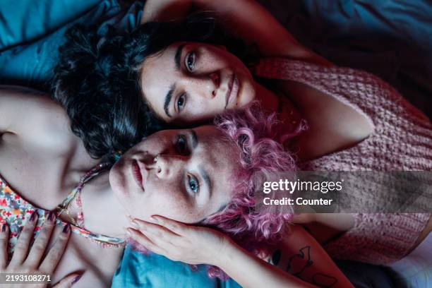 girlfriends resting together on bed - friends no makeup stock pictures, royalty-free photos & images