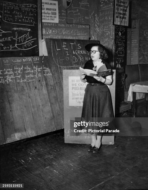 American poet Helene Mullins reading her work during a poetry night at the College of Complexes tavern in Greenwich Village, New York, 1958. The...