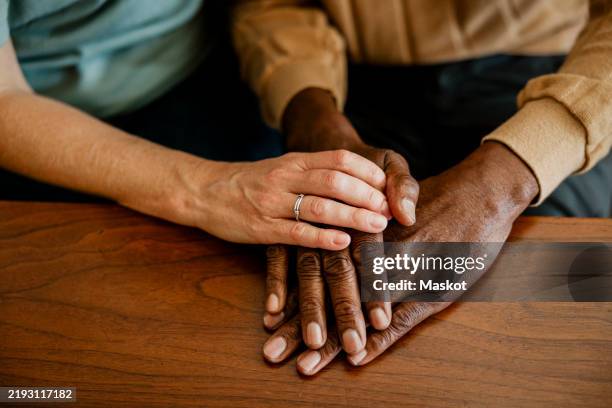 female healthcare worker consoling elderly male at home - holding hands stock pictures, royalty-free photos & images