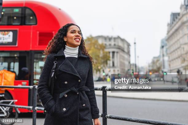 hispanic woman enjoys solo travel in london - walking stock pictures, royalty-free photos & images