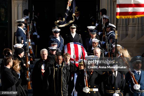 Military Body Bearers carry the flag-draped casket bearing the remains of former U.S. President Jimmy Carter from the Washington National Cathedral...