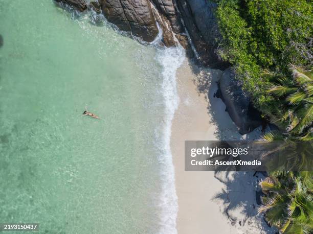 aerial view of young woman swimming in tropical lagoon - solo travel stock pictures, royalty-free photos & images