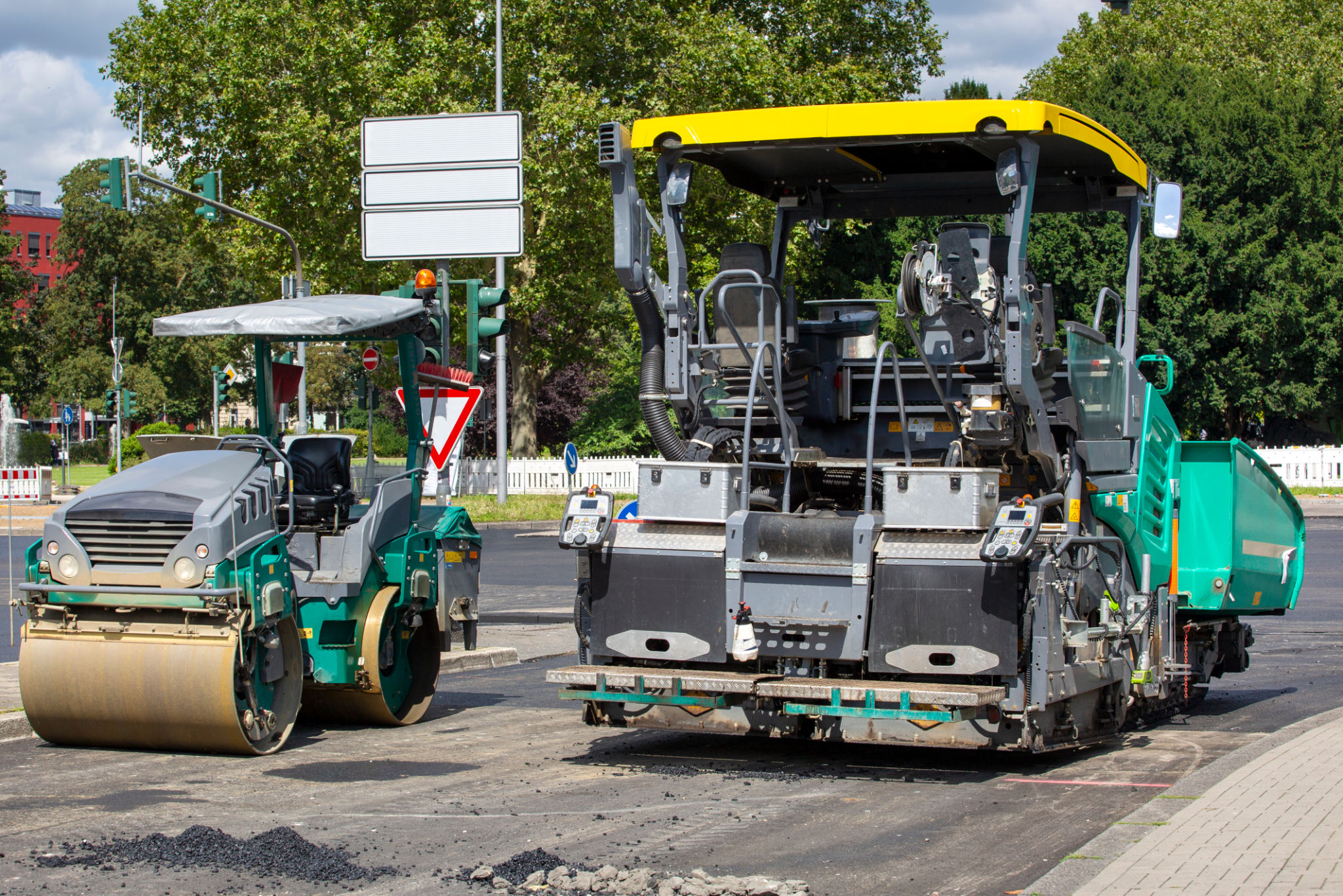 Road construction site and asphalt paving machine Road construction site and asphalt paving machine