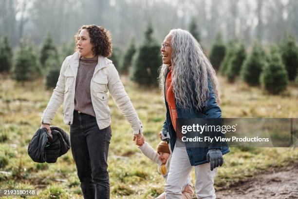 multi-generation family visiting you-cut christmas tree farm - grandmother walking stock pictures, royalty-free photos & images
