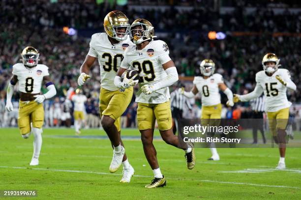 Christian Gray of the Notre Dame Fighting Irish celebrates with teammates after making an interception during the fourth quarter against the Penn...