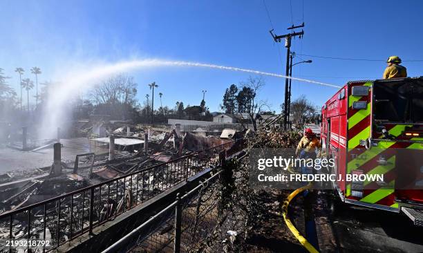Firefighters water down smoky embers as the fire ravaged Sahag Mesrob Armenian Christian School on January 13, 2025 in Altadena, California, where...