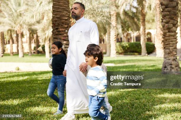 le week-end, un père de trois enfants emmène ses enfants au parc de riyad. - culture saoudienne photos et images de collection