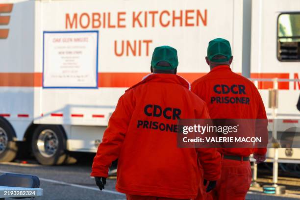 Inmates working at the camp take a dinner break at the first responders base camp set up at Zuma Beach, on January 12 in Malibu, California. A huge...