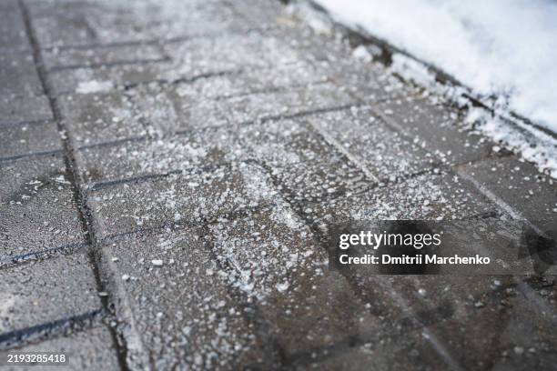 anti-icing chemicals, street treated with technical salt or de-icing chemicals, closeup view - salz streuen stock-fotos und bilder