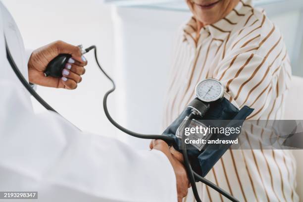 healthcare professional measuring blood pressure - hypertensive stock pictures, royalty-free photos & images