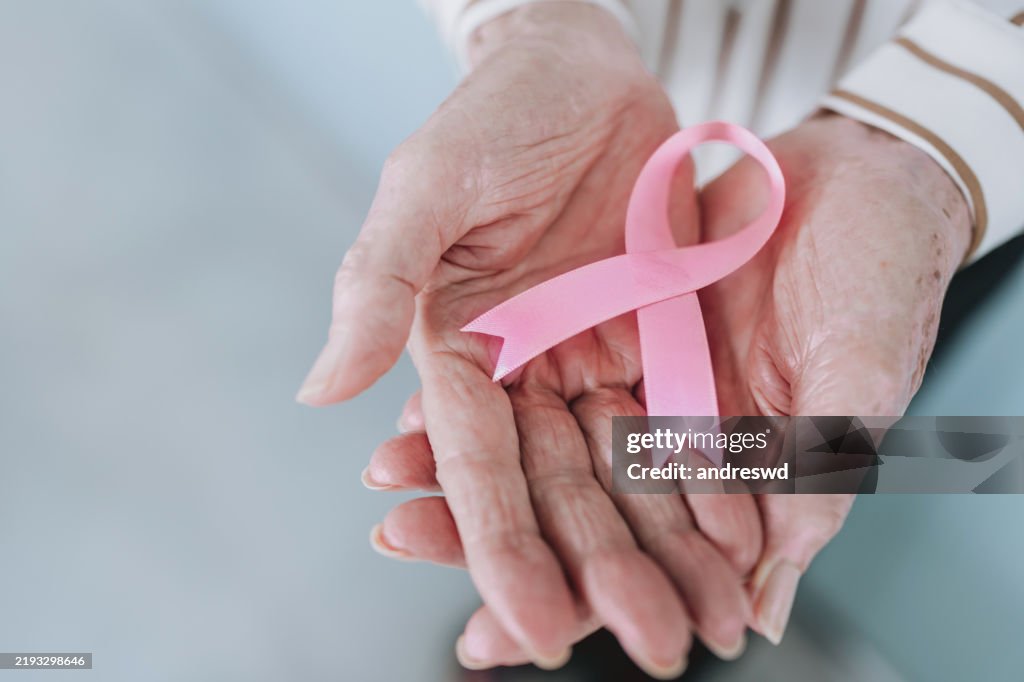 Hände mit rosa Schleife, Bewusstsein für Brustkrebs