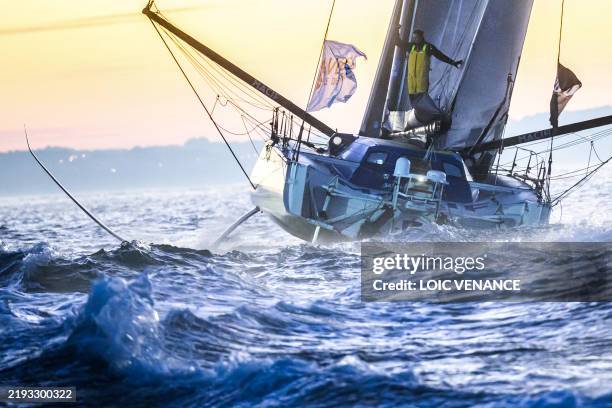 French skipper Charlie Dalin celebrates aboard his Imoca 60 monohull "Macif" as he crosses the finish line of the 10th edition of the Vendee Globe...