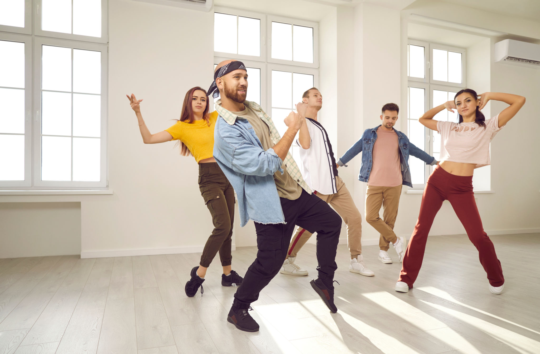 Group of happy young men and women having a dancing class in a modern dance studio Group of happy young men and women having a dancing class in a modern dance studio
