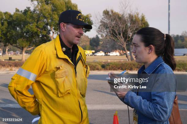 Los Angeles County Fire Department spokesperson Arthur Lester is interviewed by Los Angeles Times reporter Grace Toohey during an Eaton Fire press...