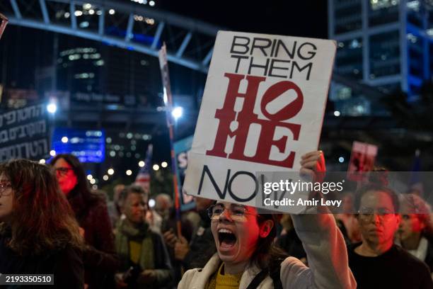 Protester holds a sign during a demonstration calling for the return of hostages held by Hamas after the deadly Oct 7 attack January 14, 2025 Tel...
