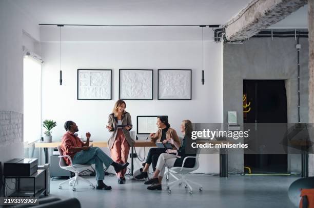 young professionals collaborating in a modern design studio environment - roupa descontraída imagens e fotografias de stock