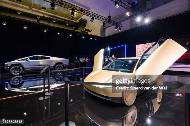 Tesla Cybercab or Robotaxi two-passenger battery-electric self-driving car and Tesla Cybertruck battery electric pickup truck on display at the 2025...