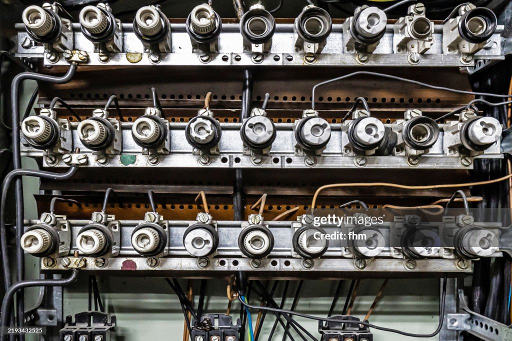 Many old fuses in a large fuse box in an abandoned building