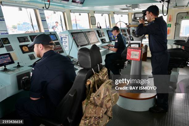 Crew members demonstrate their duties on the bridge of the British Royal Navy's HMS Spey, a River-class Batch 2 offshore patrol vessel, while docked...