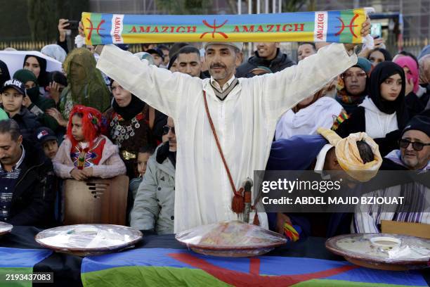 Man holds up a sign during celebrations of the Amazigh New Year 2975, in Rabat, on January 14, 2025.