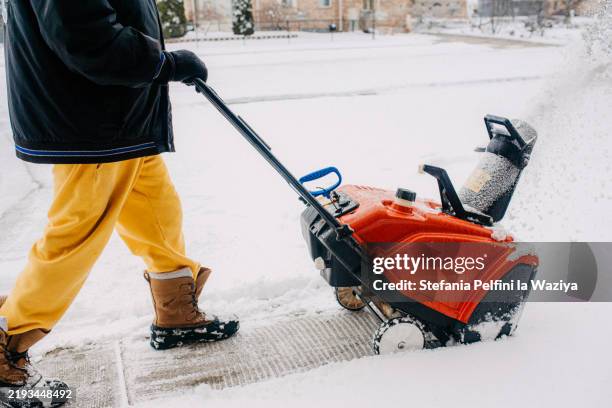 person using a red snowblower - snowplough stock pictures, royalty-free photos & images