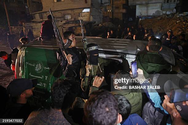 Members of Hamas's armed wing, the Ezzedine al-Qassam Brigades, arrive in a vehicle at a street in Khan Yunis in the southern Gaza Strip on January...