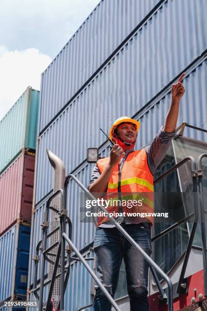 engineers are using walkie-talkies to communicate inside a container warehouse. - industrial sailing craft stock pictures, royalty-free photos & images