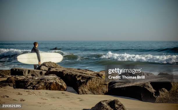 surfer surveying the waves - asbury park stock pictures, royalty-free photos & images