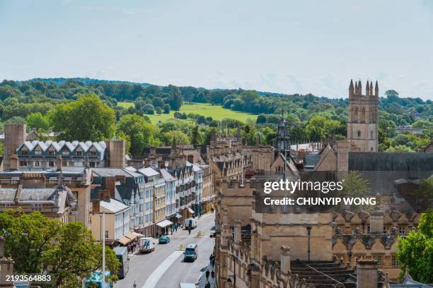 oxford city center with magdalen tower and lush green hills in background - oxford england stock pictures, royalty-free photos & images